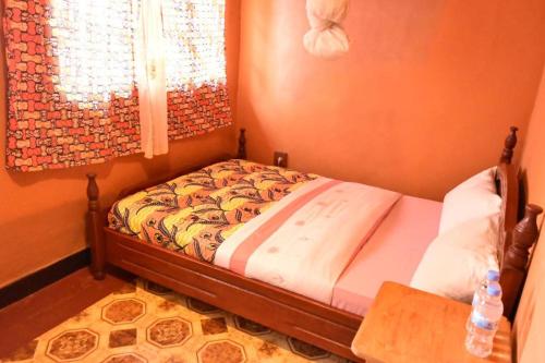 a small bed in a room with a window at Room in BB - Amahoro Guest House - Double Room with Private Shower Room in Ruhengeri