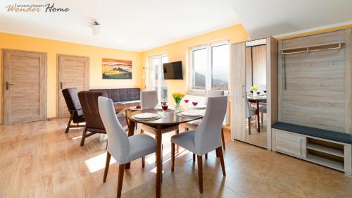 a dining room and living room with a table and chairs at Wonder Home - Cicha 13, apartamenty z balkonami, blisko centrum in Świeradów-Zdrój