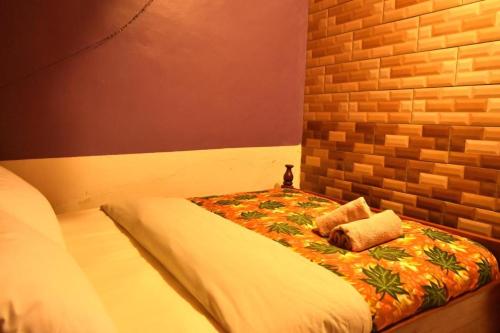 Cama en habitación con pared de ladrillo en Room in BB - Amahoro Guest House - Single Room with Shower en Ruhengeri