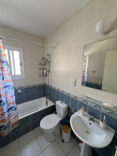 een badkamer met een wastafel, een toilet en een bad bij Iris Village Grand Apartment in Paphos City