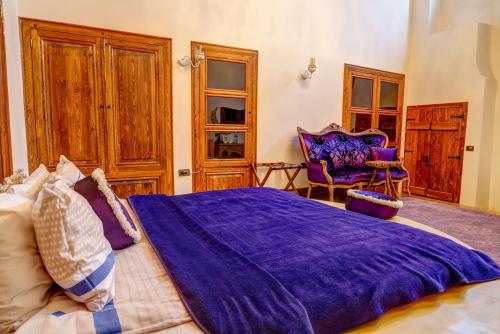 a bedroom with a large purple bed and a chair at Kerem ile Aslı Butik Hotel in Melikgazi