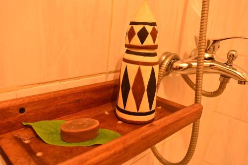 a bathroom sink with a vase and a bar of soap at Room in BB - Amahoro Guest House - Triple Room with Shared Bathroom in Ruhengeri