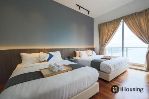 a hotel room with two beds and a window at Silverscape Deluxe Melaka by I Housing in Melaka