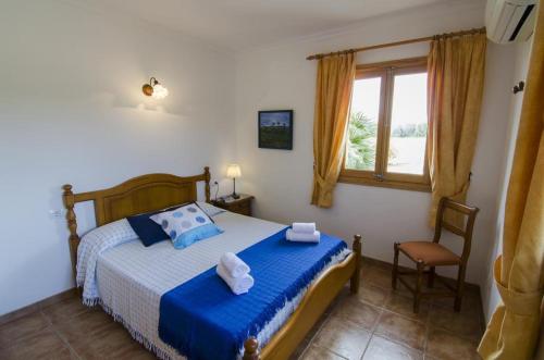 une chambre avec un lit avec des draps bleus et une fenêtre dans l'établissement Finca Can Confit - Grupo Berna, à Campos