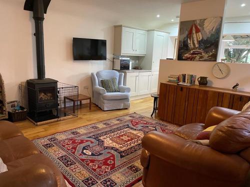 a living room with a couch and a stove at Teal Cottage, Killlyleagh in Killyleagh