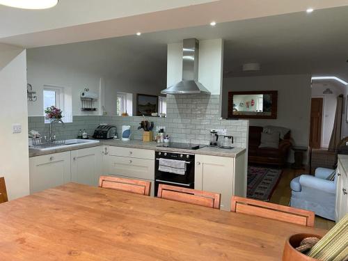 a kitchen with a table and a dining room at Teal Cottage, Killlyleagh in Killyleagh