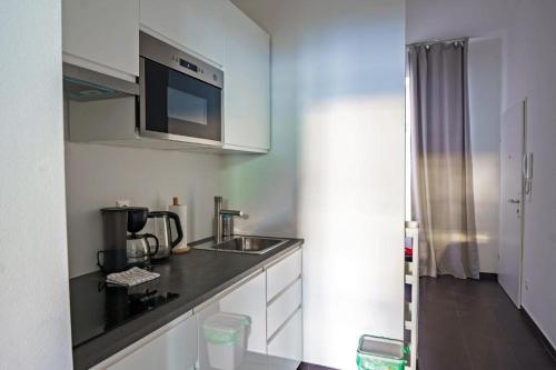 cocina con fregadero y microondas en Vienna Lights Apartments - Angeligasse, en Viena