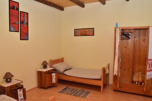 um quarto com uma cama e um armário de madeira em Guest house Jurini Dvori em Kneževi Vinogradi