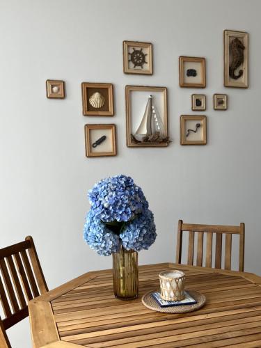 a table with a vase of blue flowers on it at Esplanada do Ilhéu in Vila Franca do Campo
