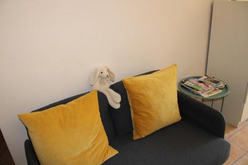 a stuffed animal sitting on top of a couch with pillows at Agréable appartement P2 Centre ville au calme. in Nîmes