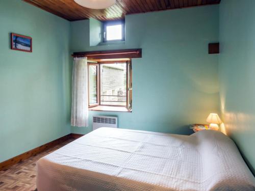 1 dormitorio con cama blanca y ventana en Gîte Sauvain, 4 pièces, 6 personnes - FR-1-496-42 en Sauvain