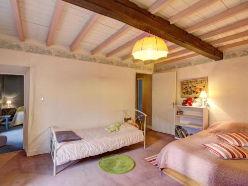 a room with two beds and a table in it at Gîte Saint-Alban-les-Eaux, 7 pièces, 10 personnes - FR-1-496-95 in Saint-Alban-les-Eaux