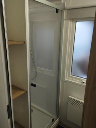 d'un placard avec une porte en verre et une fenêtre. dans l'établissement mobil-home k121 au camping les Charmettes, aux Mathes