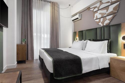 a hotel room with a large bed and a window at Acropolis Select in Athens