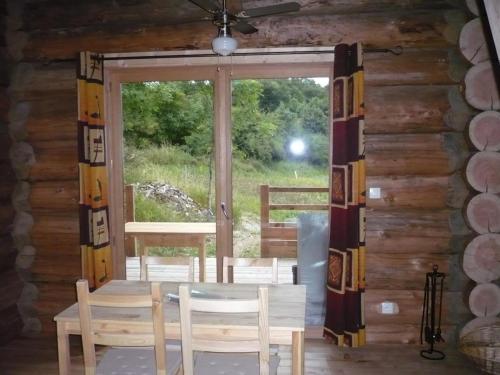 une pièce avec une table, des chaises et une fenêtre dans l'établissement Chalet chaleureux avec poêle à bois et internet à Saint-Martin-la-Sauveté - FR-1-496-184, à Saint-Martin-la-Sauveté
