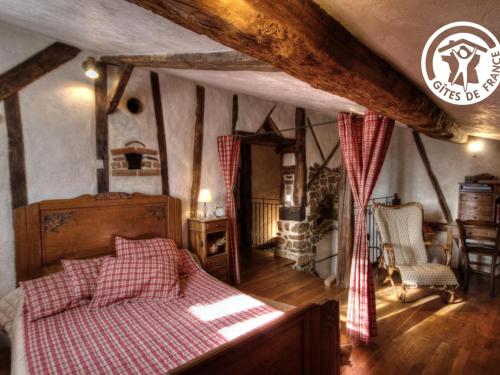 um quarto com uma cama com um cobertor xadrez vermelho e branco em Gîte Chirassimont, 2 pièces, 4 personnes - FR-1-496-137 em Chirassimont