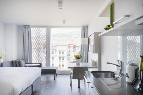 a kitchen and living room with a bed and a sink at Base Vevey in Vevey
