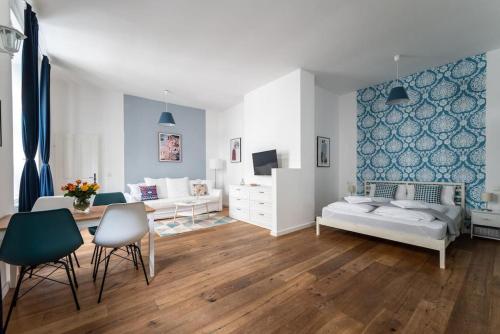 ein Wohnzimmer mit einem Bett, einem Tisch und Stühlen in der Unterkunft HM • Chic Studio Near Metro & Center in Wien