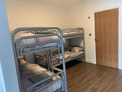 a room with three bunk beds and a door at Achill Surf Lodge in Mayo