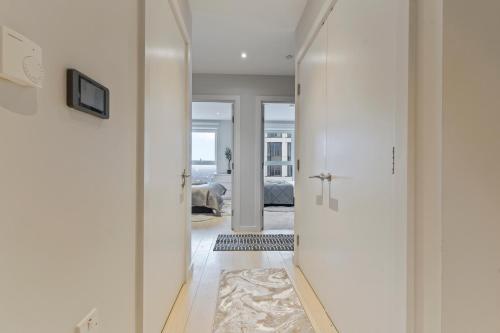 a hallway leading to a living room with white walls at Elegant 2 bed flat on 20th floor near many attractions in London