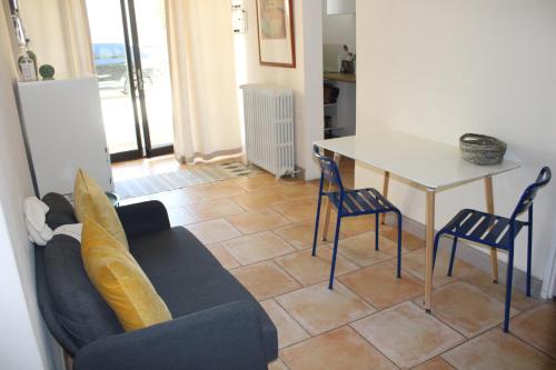a living room with a couch and a table and chairs at Agréable appartement P2 Centre ville au calme. in Nîmes