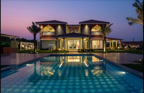 a house with a swimming pool in front of a house at Redhomex Cove Castle Villa in Hyderabad