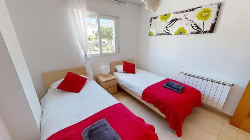 2 camas en un dormitorio con sábanas rojas y blancas en Casa Fresa, A Simply Spanish Rentals Property, en Murcia