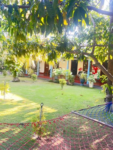 a fence in front of a yard with a tree at Lobster Inn in Trincomalee