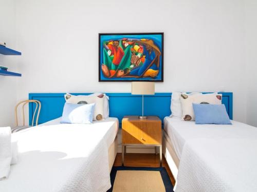 two beds in a room with a painting on the wall at Laguna 25 House - Privat Pool & Games Room & Gym & Jacuzzi in Quarteira