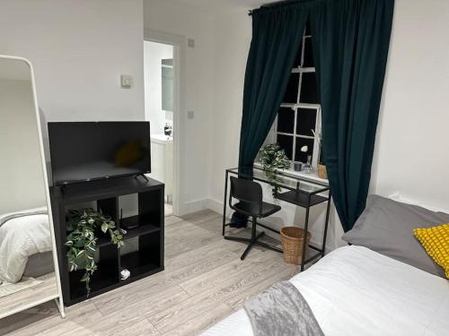 a bedroom with a bed and a desk with a television at Entire One Bedroom Rental Unit in Kent in Kent