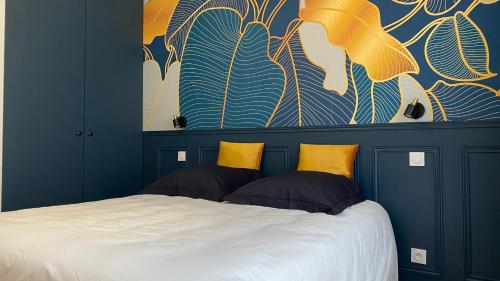 ロリアンにあるAppartement Apollinaire au cœur de Lorientのベッドルーム1室(大型ベッド1台、黄色い枕付)