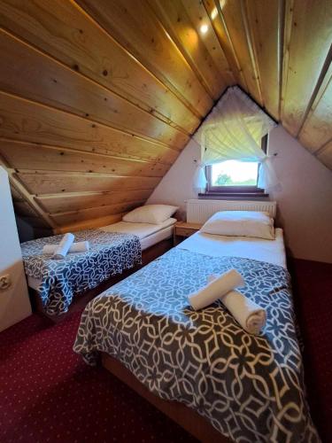 a bedroom with two beds in a wooden cabin at Apartament u Chowańców (blisko baseny termalne) in Bańska Niżna