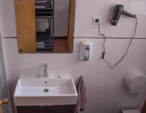 a bathroom with a sink and a phone on the wall at Onefam Madrid in Madrid