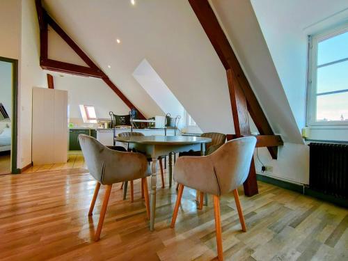 - une salle à manger mansardée avec une table et des chaises dans l'établissement Home - Jean Jaurés - Séjour à Auxerre, à Auxerre