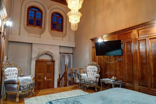 a living room with two chairs and a flat screen tv at Kerem ile Aslı Butik Hotel in Melikgazi