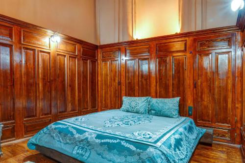 a bedroom with wooden walls and a bed with blue sheets at Kerem ile Aslı Butik Hotel in Melikgazi