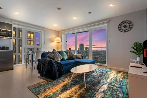 a living room with a blue couch and a large window at Elegant 2BR flat on 20th floor near many attractions in London