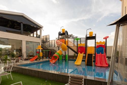 a swimming pool with a playground with a slide at النخيل رست in Al Shafa
