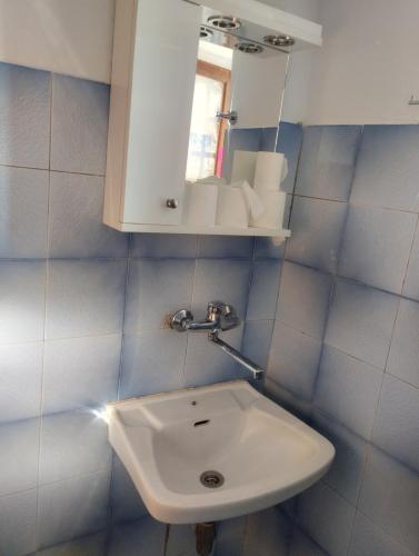 a bathroom with a white sink and a mirror at Virgin Beauty in Armenistis