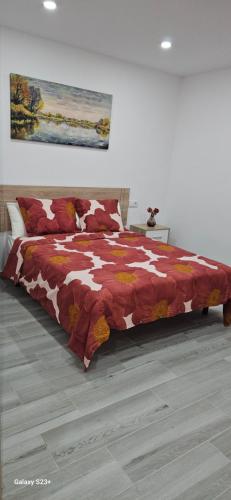um quarto com uma cama com um cobertor vermelho e branco em chalet El campillo em Sevilha