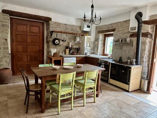 uma cozinha com uma mesa de madeira e cadeiras amarelas em Villa delle Fonti - Villa with pool em Toano