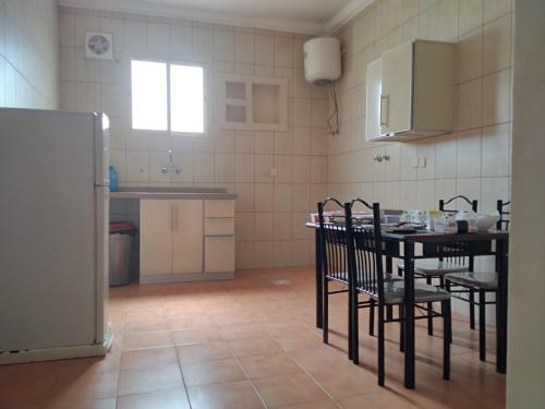 a kitchen with a table and chairs and a refrigerator at شقق مساكن ابيات للشقق المخدومة in Al Rass