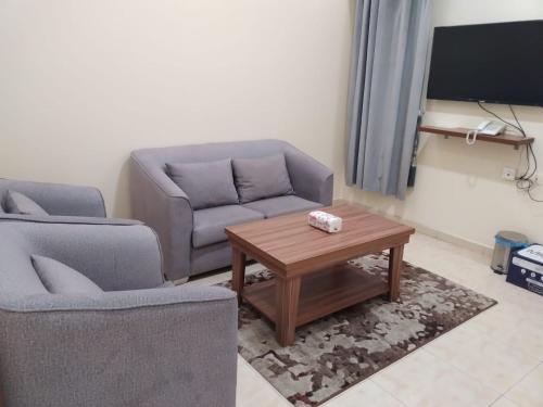 sala de estar con 2 sillas y mesa de centro en شقق مساكن ابيات للشقق المخدومة en Al Rass