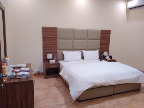 a bedroom with a large bed with a large headboard at شقق مساكن ابيات للشقق المخدومة in Al Rass