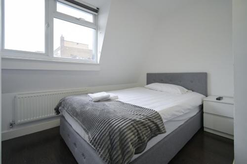 a bed in a white room with a window at Charlotte Street Rooms by News Hotel in London