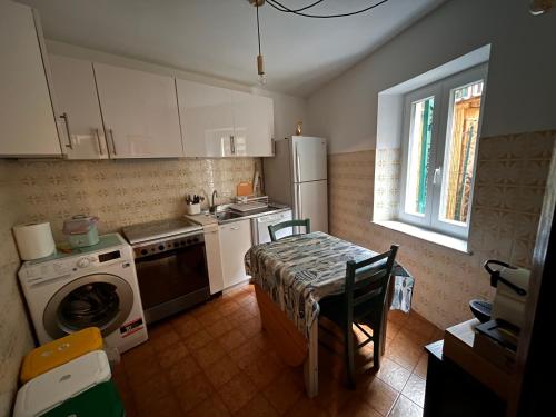 a kitchen with a table and a washer at RioRooms La Valletta Riomaggiore Center in Riomaggiore