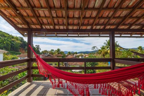 a red hammock on a balcony with a view at Pousada Recanto da Ladeira in Paraty