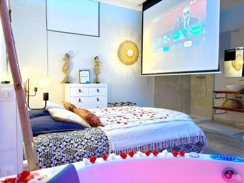 1 dormitorio con cama y pantalla grande en The Pearl - Jacuzzi SPA - Ecran géant - Parking, en Le Havre