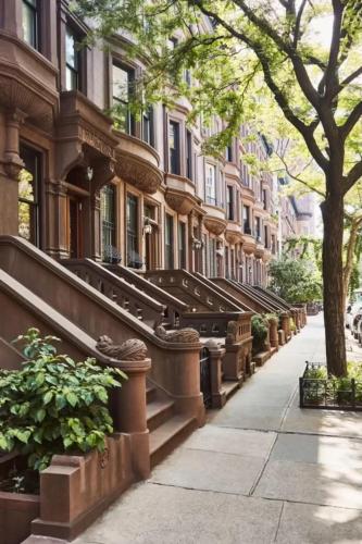 a building with a row of stairs on a city street at Townhouse in Uptown Manhattan in New York