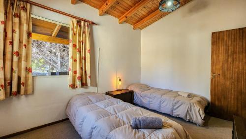 a bedroom with two beds and a window at La gringa 1 in San Carlos de Bariloche
